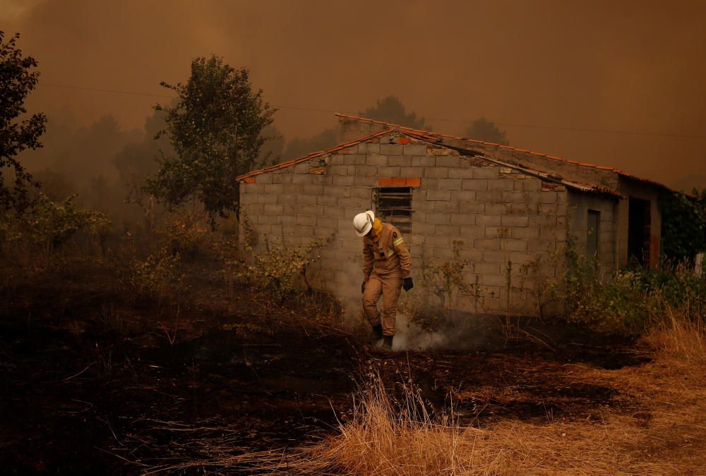 Un bombero trabaja para apagar un incendio forestal en el pueblo de Carvoeiro, cerca de Castelo Branco, Portugal.