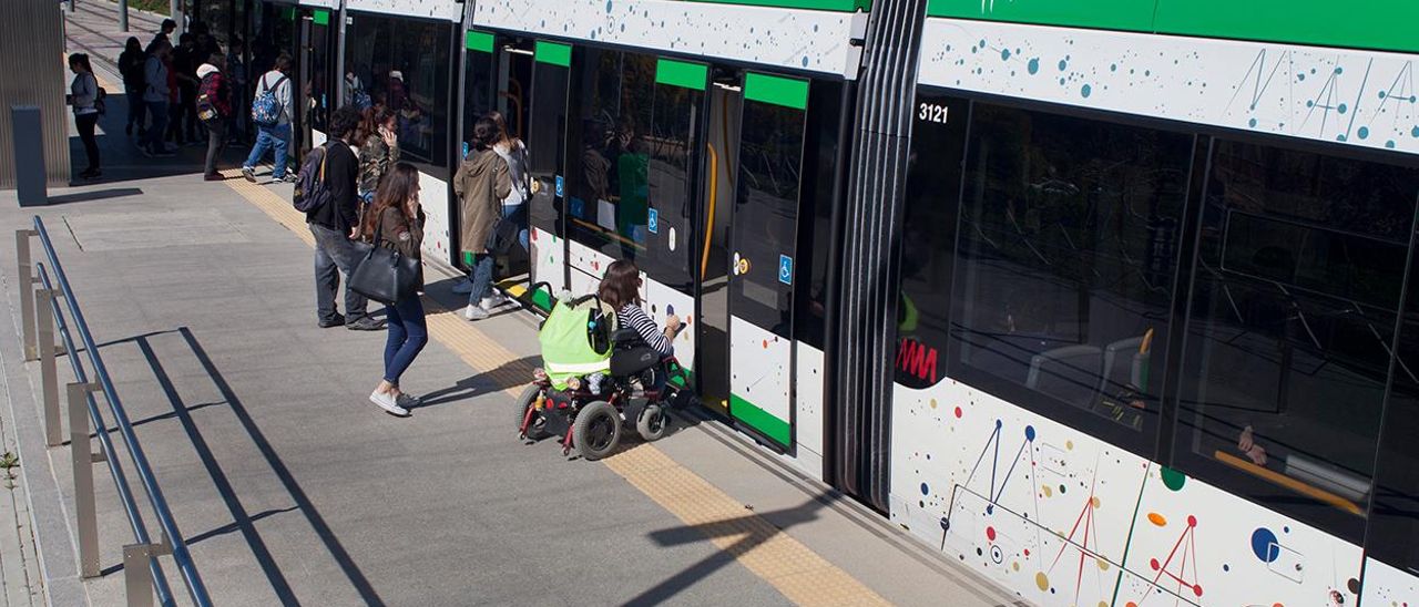 Una joven accede al metro en su silla de ruedas desde la parada de la Universidad.