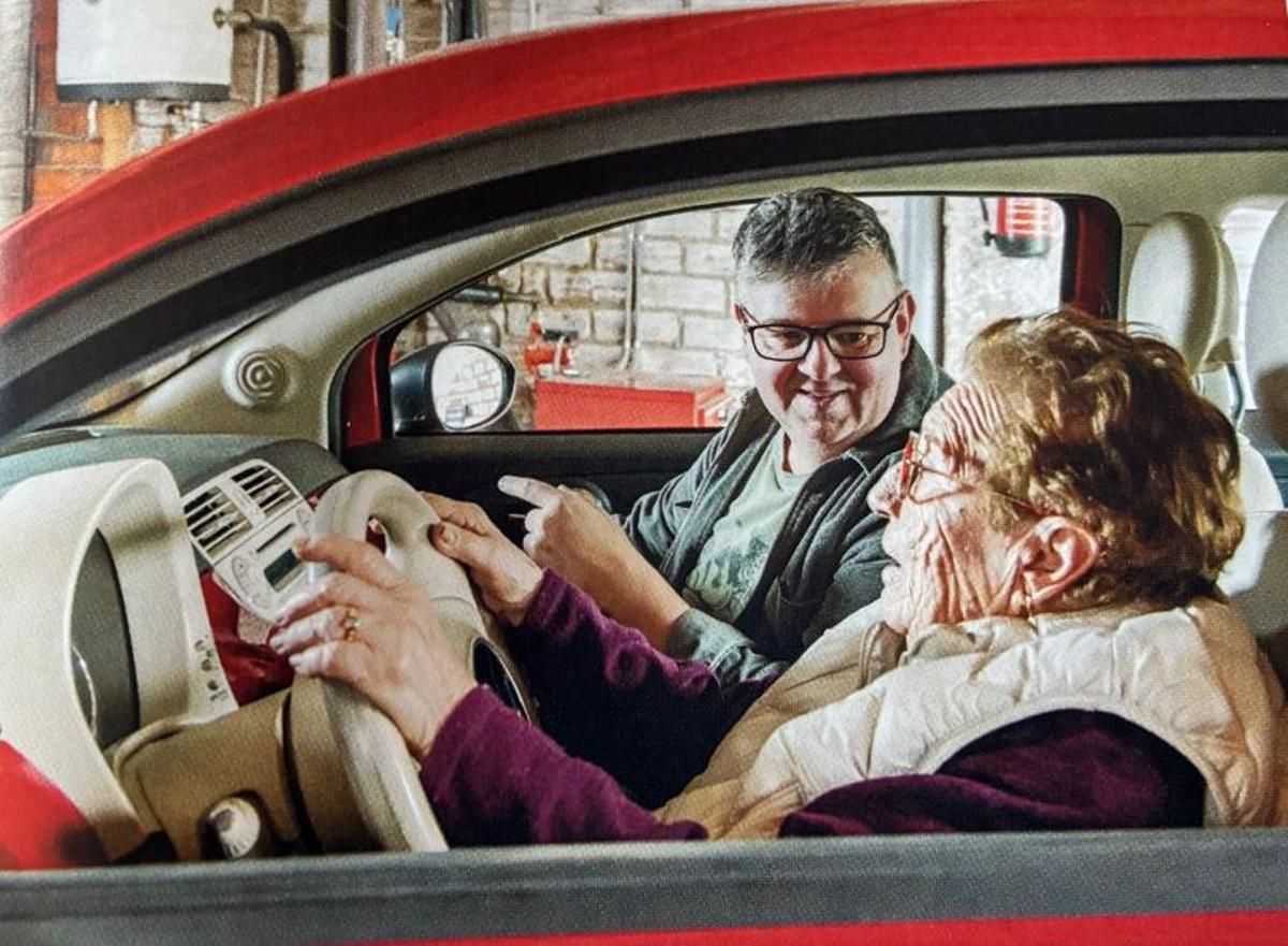 La Iaia Angeleta al voltant del seu Fiat 500 vermell, en una altra imatge del llibre.