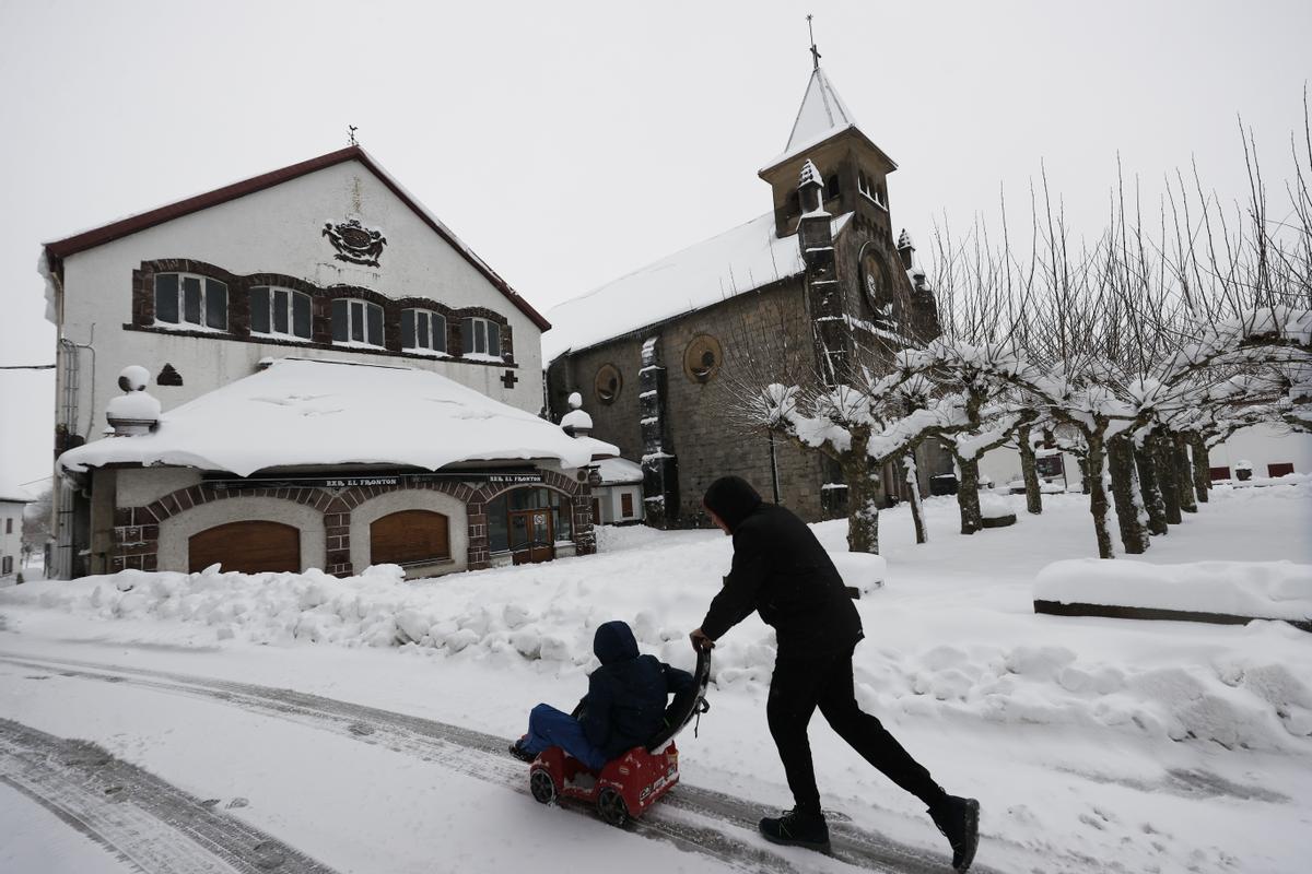 Dos niños disfrutan con sus trineos entre la nieve acumulada en la localidad de Burguete. La Agencia Estatal de Meteorología ha dado alerta naranja por nieve este miércoles para toda Navarra salvo la Ribera y de nivel amarillo por riesgo de aludes para Pirineos.