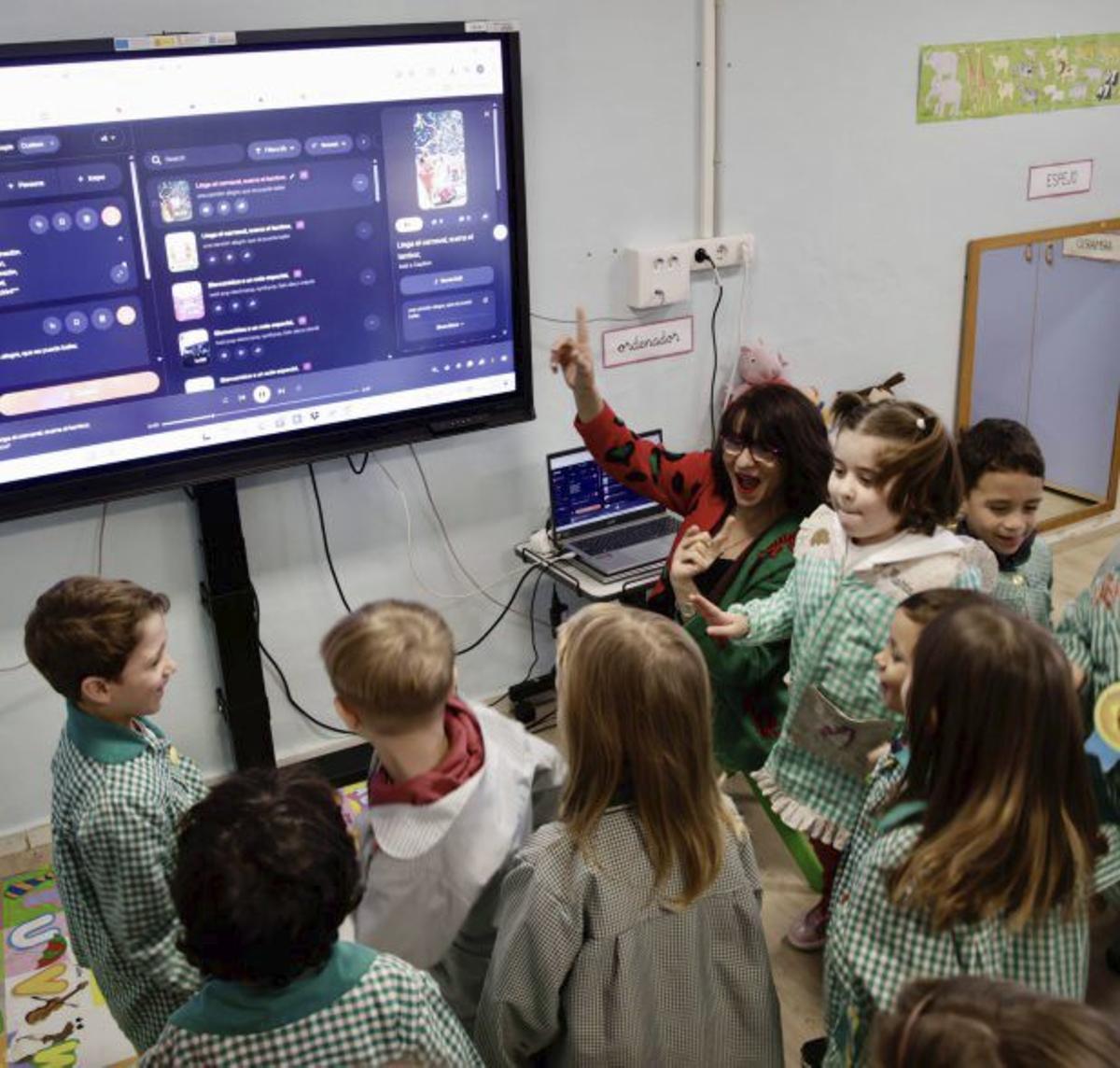 La profesora de Robótica, Magdalena de Pazos, aprende a los escolinos el cancioneru que tán creando.