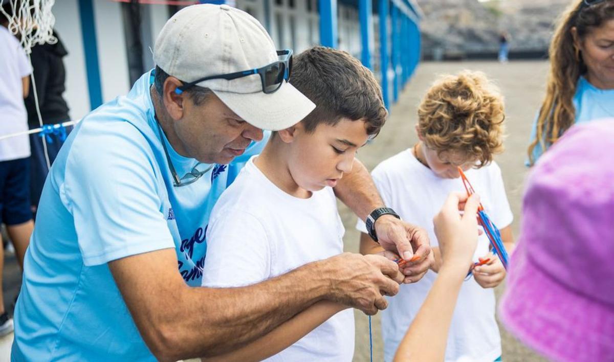 Andrés Chacón muestra a los niños cómo se cosen las mallas de red. | LP/DLP