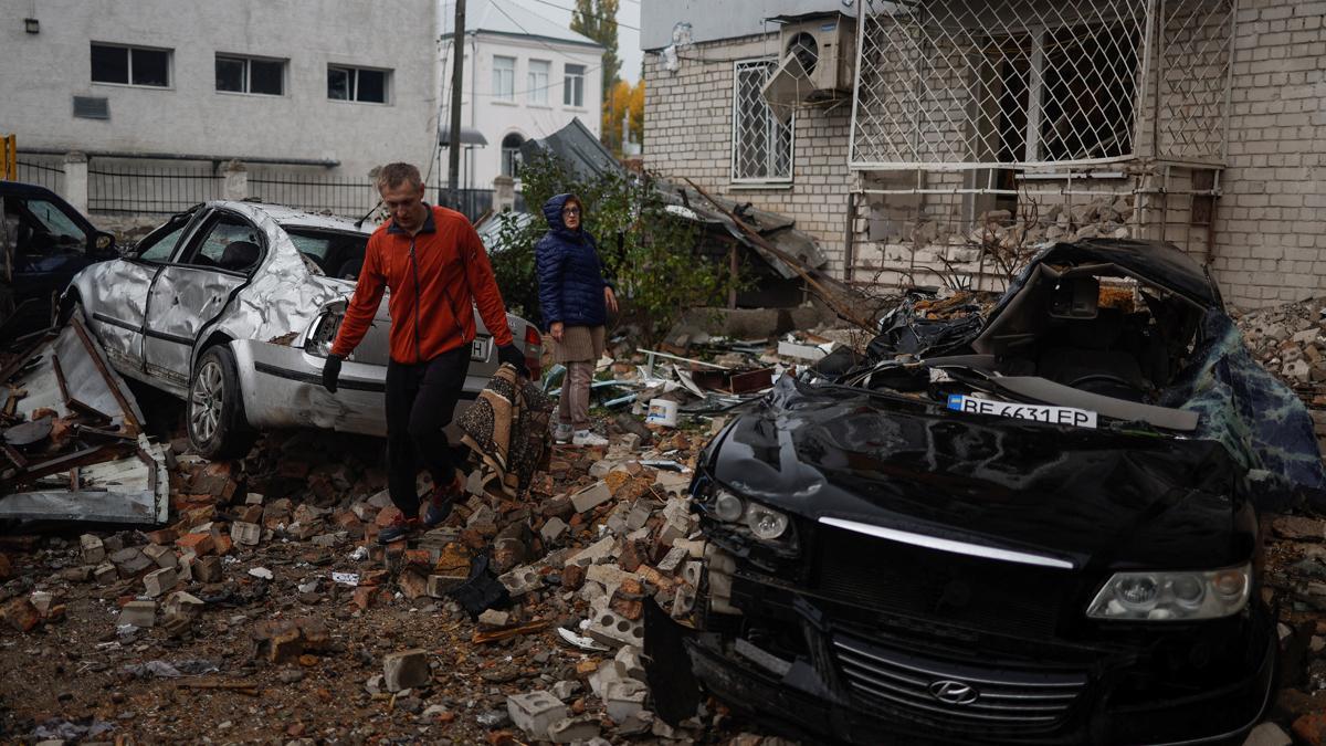 Residentes pasan entre coches destrozados tras un ataque ruso con misiles en Mykolaiv, en Ucrania