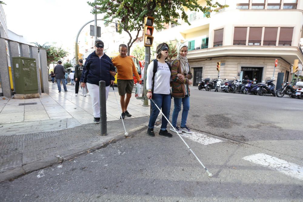 Algunas personas, entre ellos políticos, comprueban las dificultades de moverse por la calle que sufren las personas con discapacidad visual.