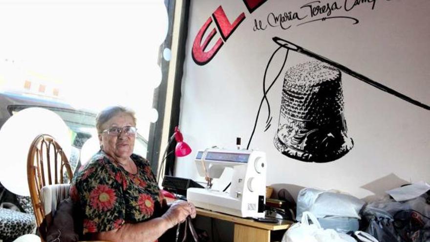 María Teresa Campos senatda frente a la máquina de coser en su taller de costura.