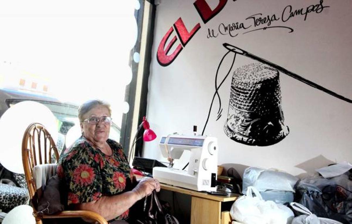 María Teresa Campos senatda frente a la máquina de coser en su taller de costura.