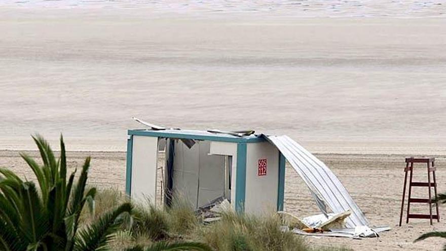 Dos agentes rastrean los alrededores de la caseta de socorristas en la playa de Laredo donde explosionó uno de los cuatro artefactos.