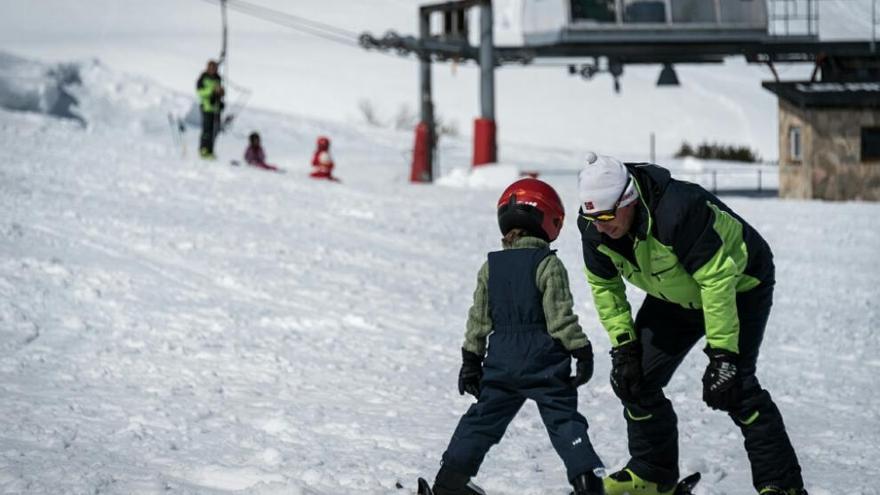 Un profesor de esquí alpino dando clases a un pequeño