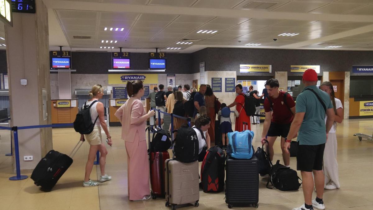 Un grupo de pasajeros espera para facturar su equipaje en el aeropuerto de Girona