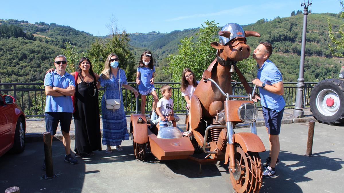 Los turistas Rafa Castellano, Sandra Ferrán, Beatriz de Paredes, Manuel Lucena y sus hijos Claudia, Diana, Blanca y Rafa posando en la escultura la “vaca motera”. | T. Cascudo