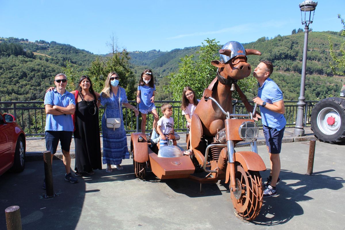 Los turistas Rafa Castellano, Sandra Ferrán, Beatriz de Paredes, Manuel Lucena y sus hijos Claudia, Diana, Blanca y Rafa posando en la escultura la “vaca motera”. | T. Cascudo
