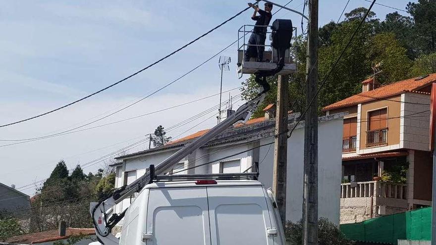 Operarios municipales arreglaban ayer una farola en la carretera general, a la altura de Tirán. // G.N.