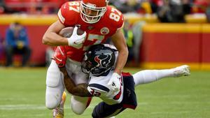 Travis Kelce # 87 de los Kansas City Chiefs es abordado por Lonnie Johnson # 32 de los Houston Texans durante el partido de desempate divisional de la AFC en el Arrowhead Stadium.