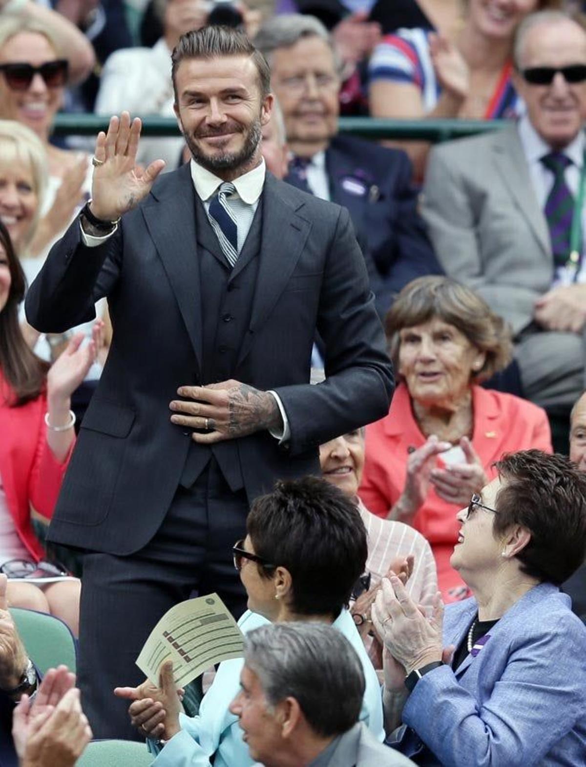 David Beckham saluda ante los aplausos recibidos antes de sentarse en una zona VIP en el torneo de Wimbledon