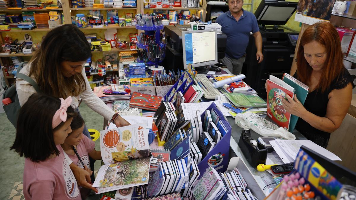 Una familia recoge sus libros de texto en una librería de Vigo.