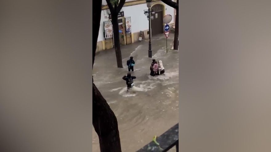 El momento en el que el agua pilla por sorpresa a una madre con sus hijos a la salida del colegio en Jerez