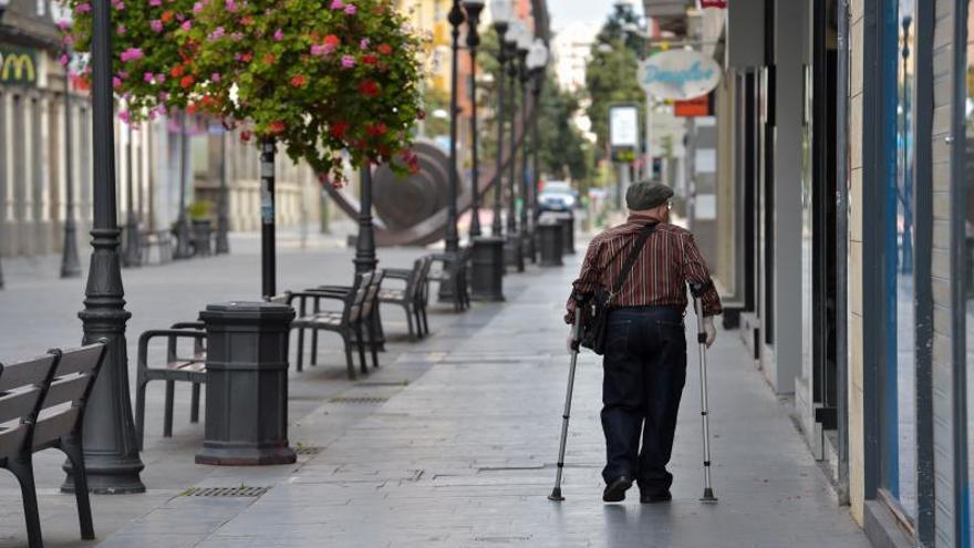 Una persona mayor caminando por Triana. | |