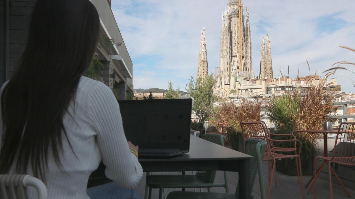 Una teletrabajadora en la terraza de la oficina de Cloudworks, enfrente de la Sagrada Família