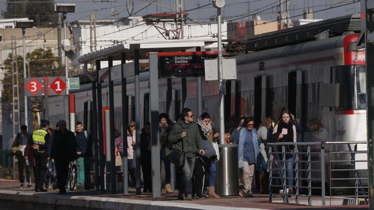 Decenas de personas suben o bajan de un tren de Cercanías en la estación de Algemesí.