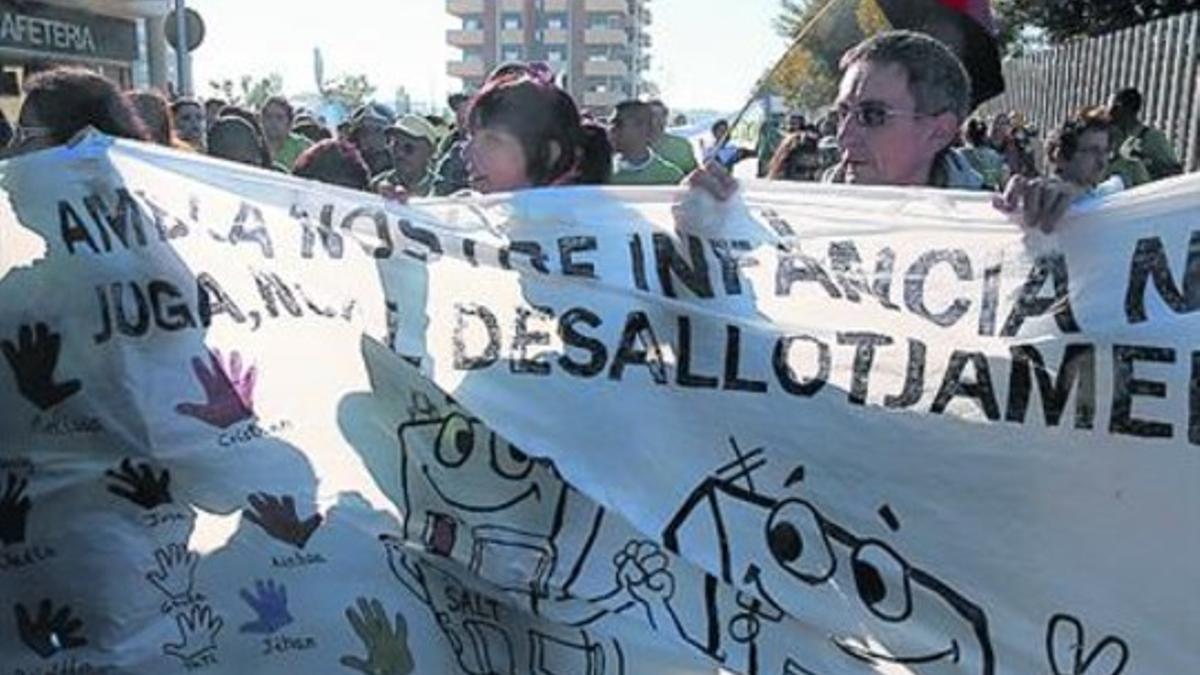Manifestación de apoyo a la ocupación del bloque de Salt, al fondo.