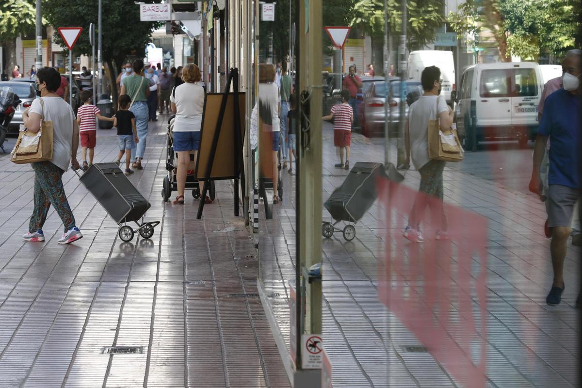 Varias personas pasean por la avenida de la Viñuela.