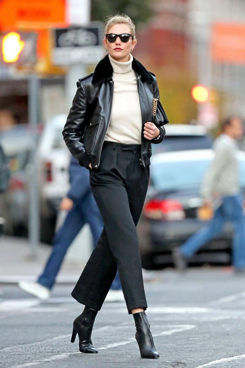 karlie Kloss con una chaqueta de aviador negra combinada con botines y pantalón del mismo color, y jersey de cuello vuelto