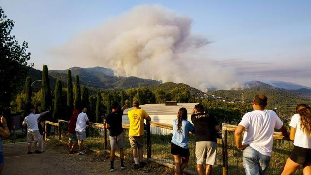 Un grup de persones mira la columna de fum de l’incendi de Sentmenat (Vallès Occidental). | QUIQUE GARCÍA / EFE