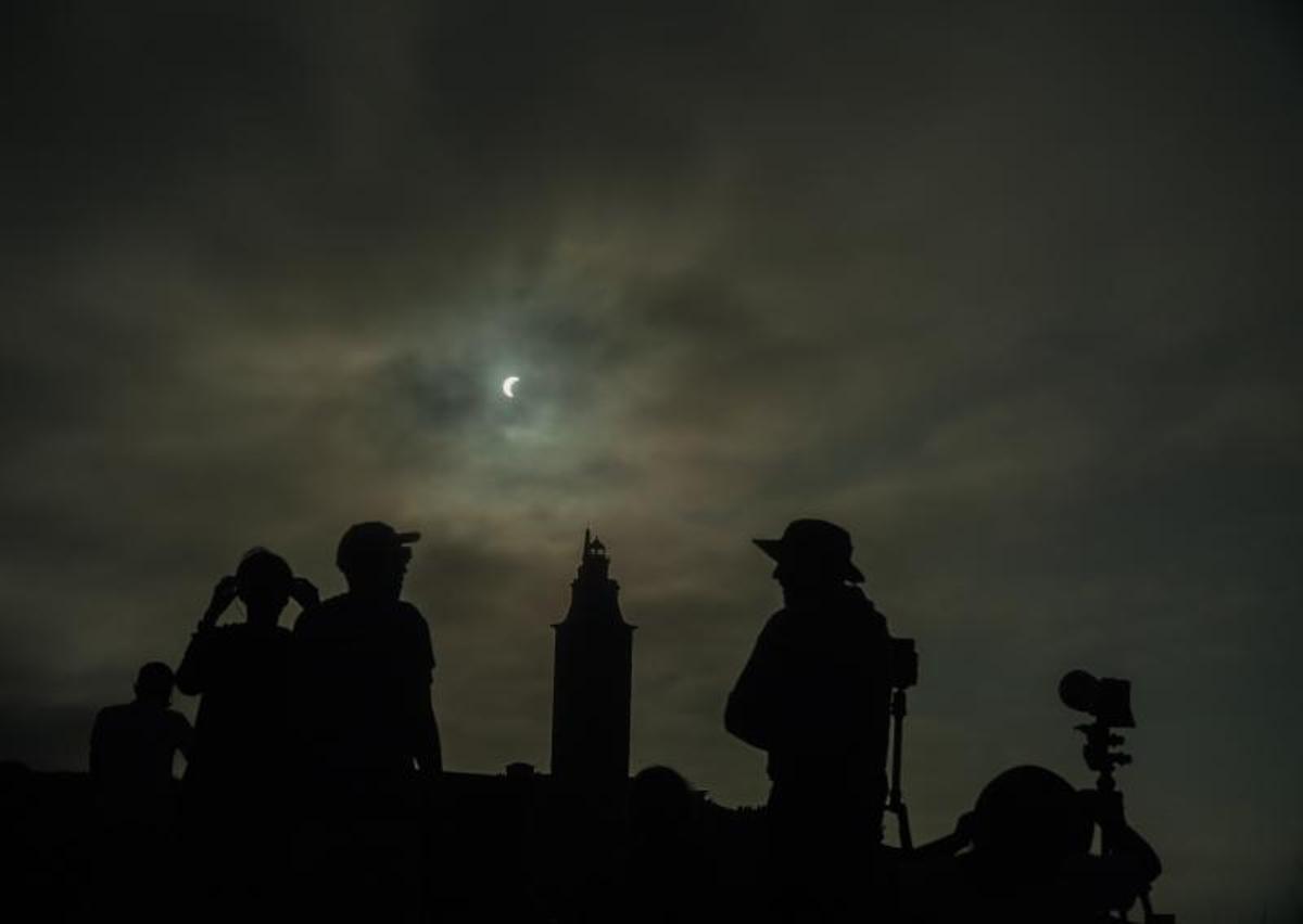 Un momento del eclipse en A Coruña, con la torre de Hércules al fondo.