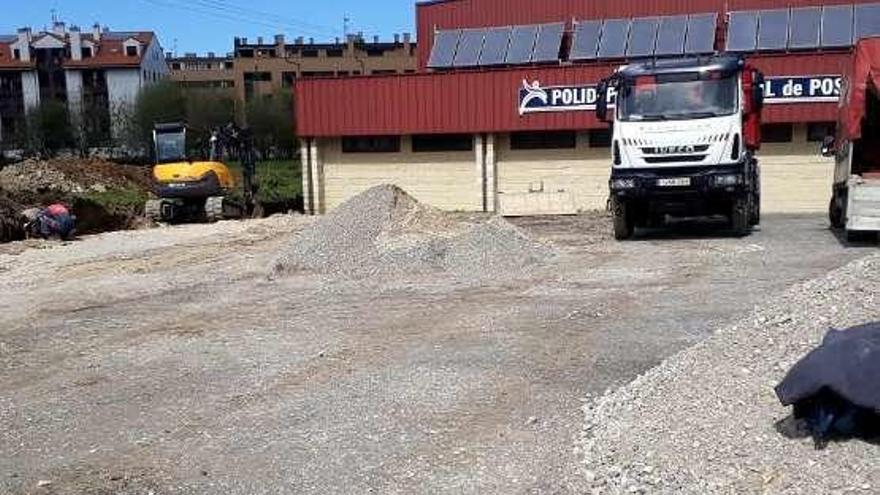 Máquinas y camiones trabajando en el aparcamiento.