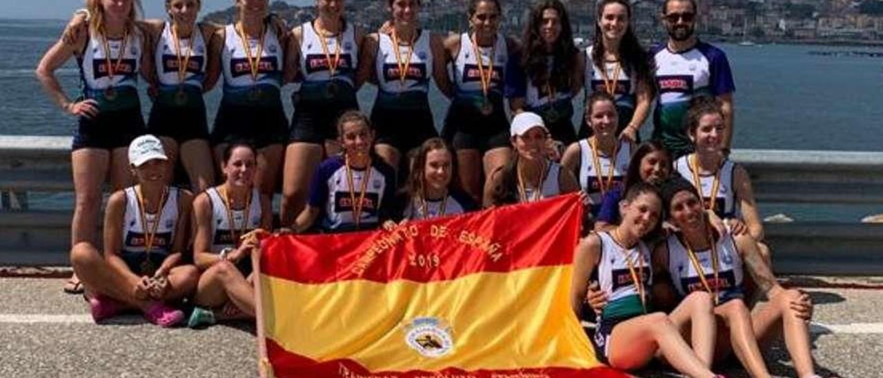 La plantilla tricéfala posa en Moaña con la bandera de campeonas de España. // FDV