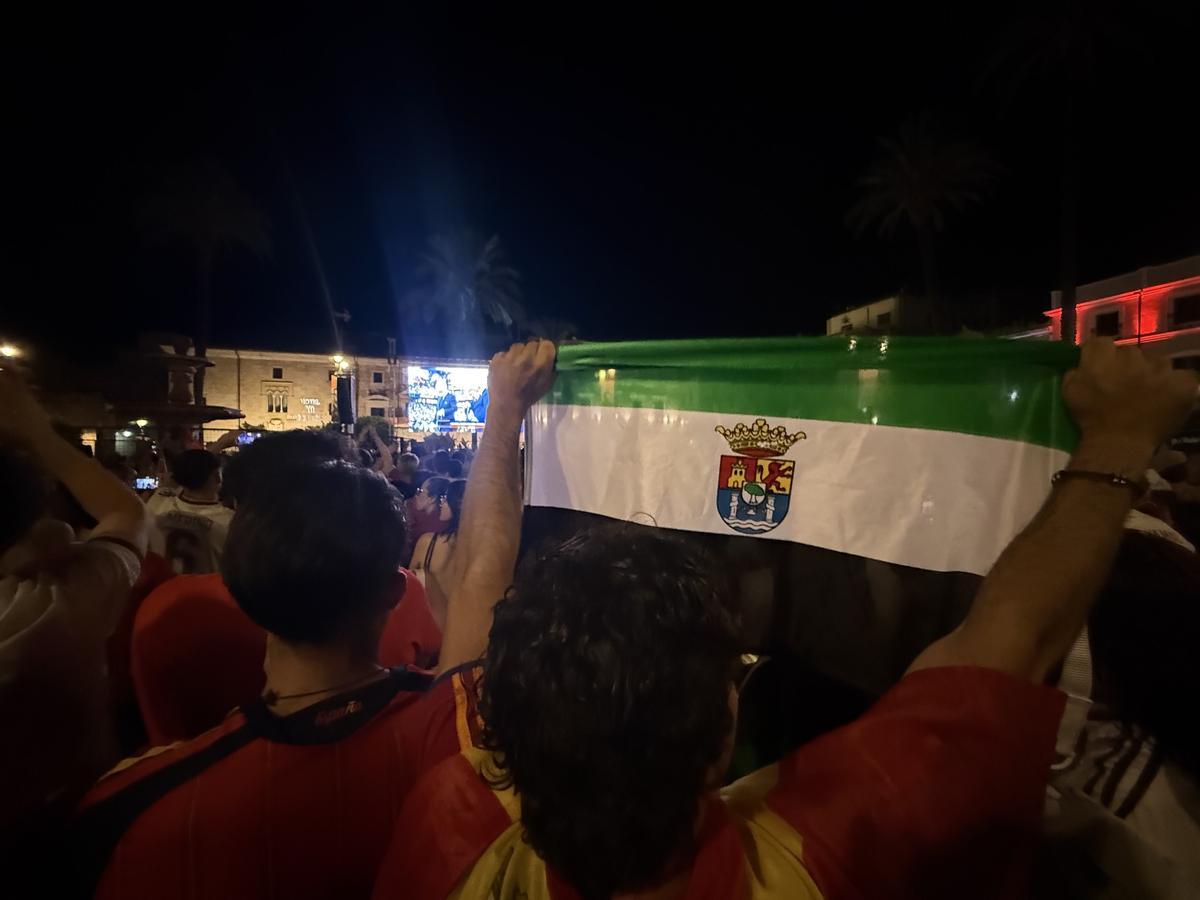 Un aficionado alza la bandera de Extremadura durante la celebración del título mundial de España en Mérida.