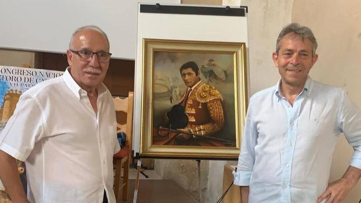 Emiliano de la Puente (derecha) junto al hijo del pintor, Florentino Domínguez, posan con el retrato.