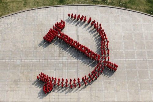 Miembros estudiantes del Partido Comunista de la Universidad de Fudan destacan en la formación para crear el emblema del partido, un martillo y una hoz