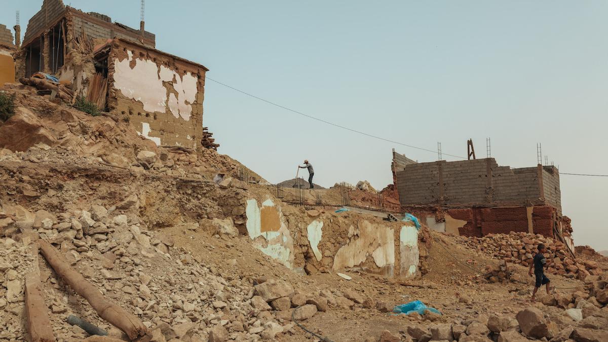 Un obrero trabaja en la construcción de una casa entre los escombros de los edificios derrumbados en el pueblo de Moulay Brahim.