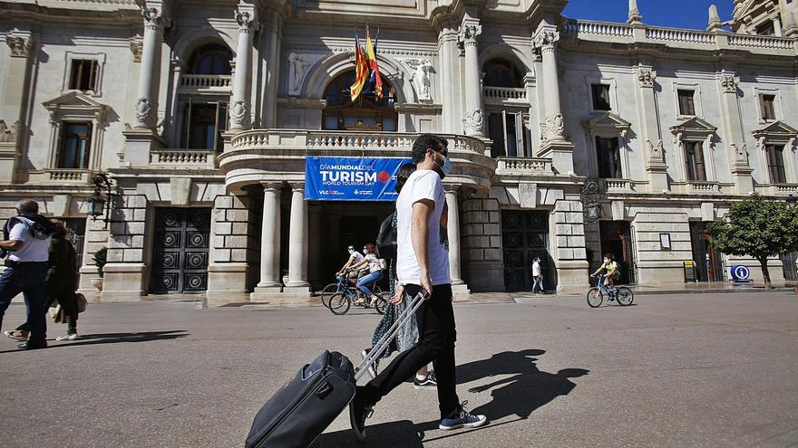 Un turista pasa por delante del Ayuntamiento de València, en una imagen del año pasado. | EDUARDO RIPOLL