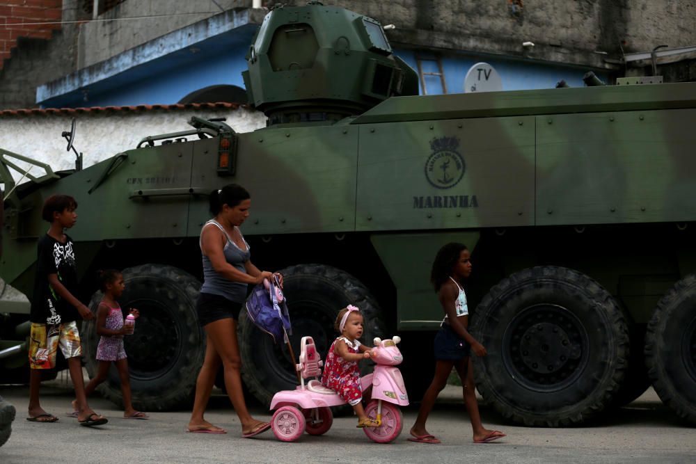 People walk as the armed forces members patrol ...