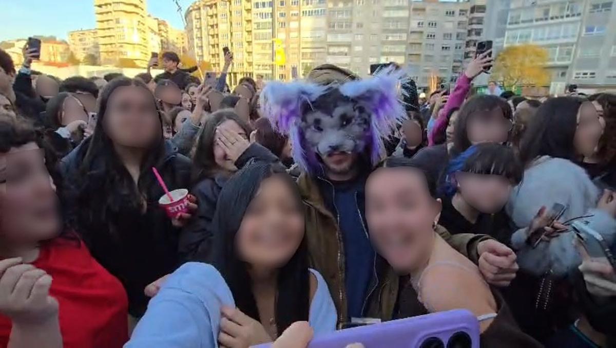 Un hombre con máscara animal junto a cientos de adolescentes.