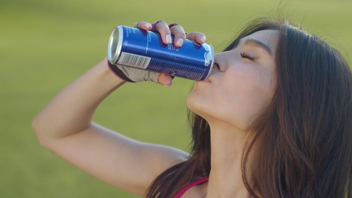 Una joven tomando una bebida energética