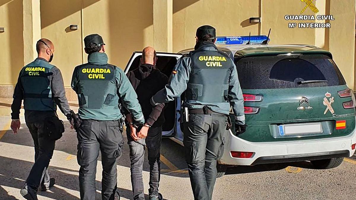 Tres agentes trasladan al detenido por la oleada de robos en coches en la Marina Alta. | INFORMACIÓN