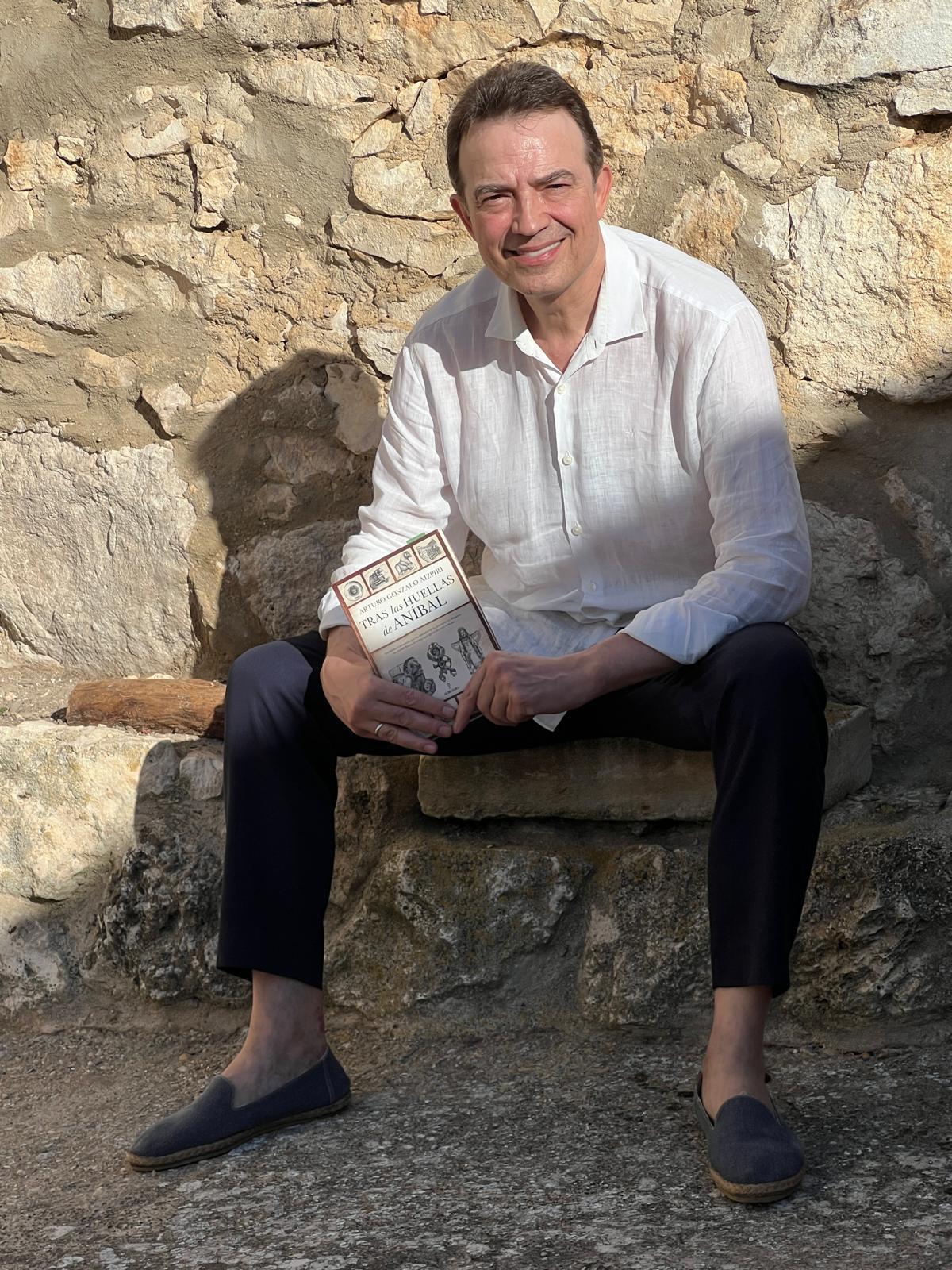 Arturo Gonzalo Aizpiri sostiene en sus manos el libro "Tras las huelals de Aníbal"