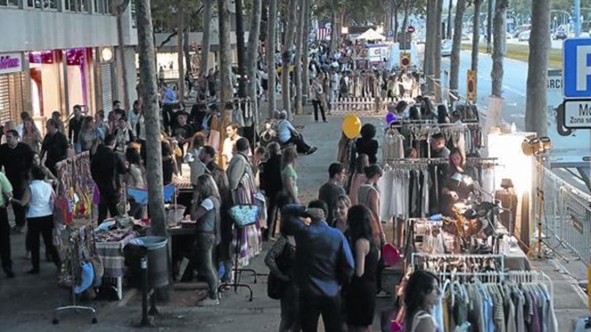 Una multitud de barceloneses y turistas pasea por la Diagonal entre el género expuesto por algunas de las tiendas que participaron en la noche de comercios abiertos.
