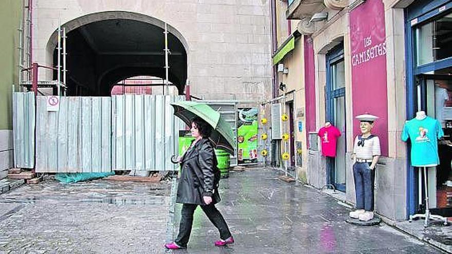 Una mujer pasa por delante del pasadizo que une las plazas Mayor y del Marqués, cerrado por obras.