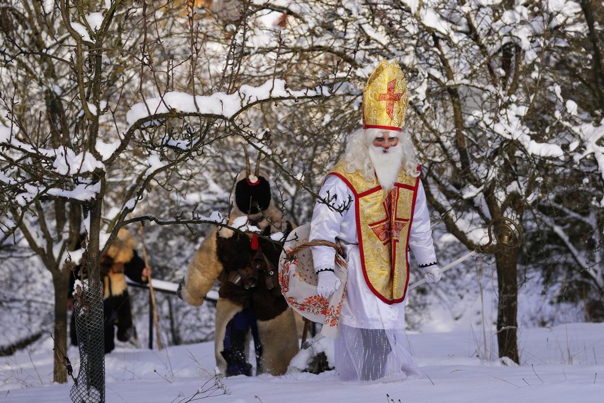 Tradicional procesión de San Nicolás en el pueblo de Lidecko, República Checa, el lunes 4 de diciembre de 2023. Esta tradición prenavideña pervive desde hace siglos en algunos pueblos del este del país. Se desfila por el pueblo durante el fin de semana, yendo de puerta en puerta. San Nicolás obsequia a los niños con caramelos. Los diablos llevan máscaras caseras de piel de oveja y las criaturas blancas que representan la muerte, van con guadañas y les asustan.