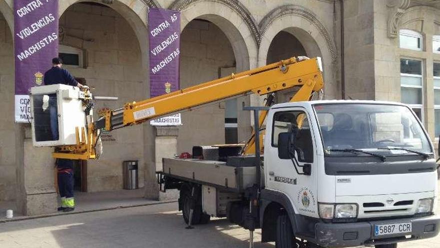 Instalación de banderolas, ayer, en los soportales del consistorio.