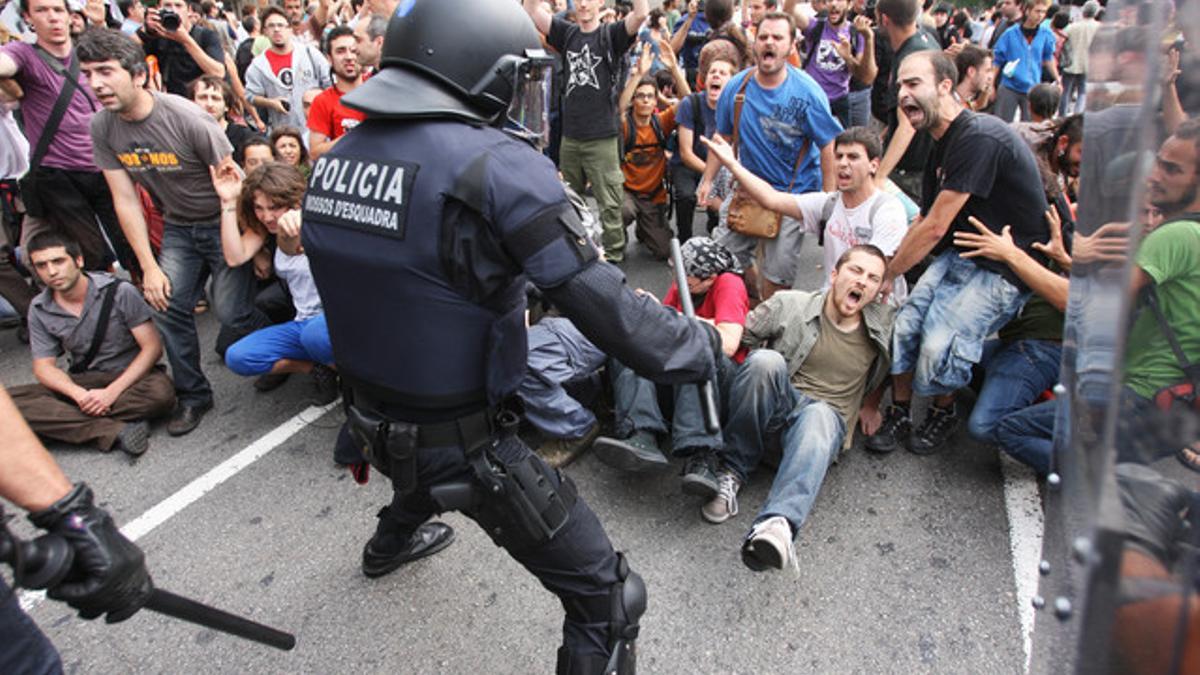 Miembros de los Mossos d'Esquadra y de la Guardia Urbana intentan desalojar a un grupo de indignados en la plaza de Catalunya, el pasado 27 de mayo.