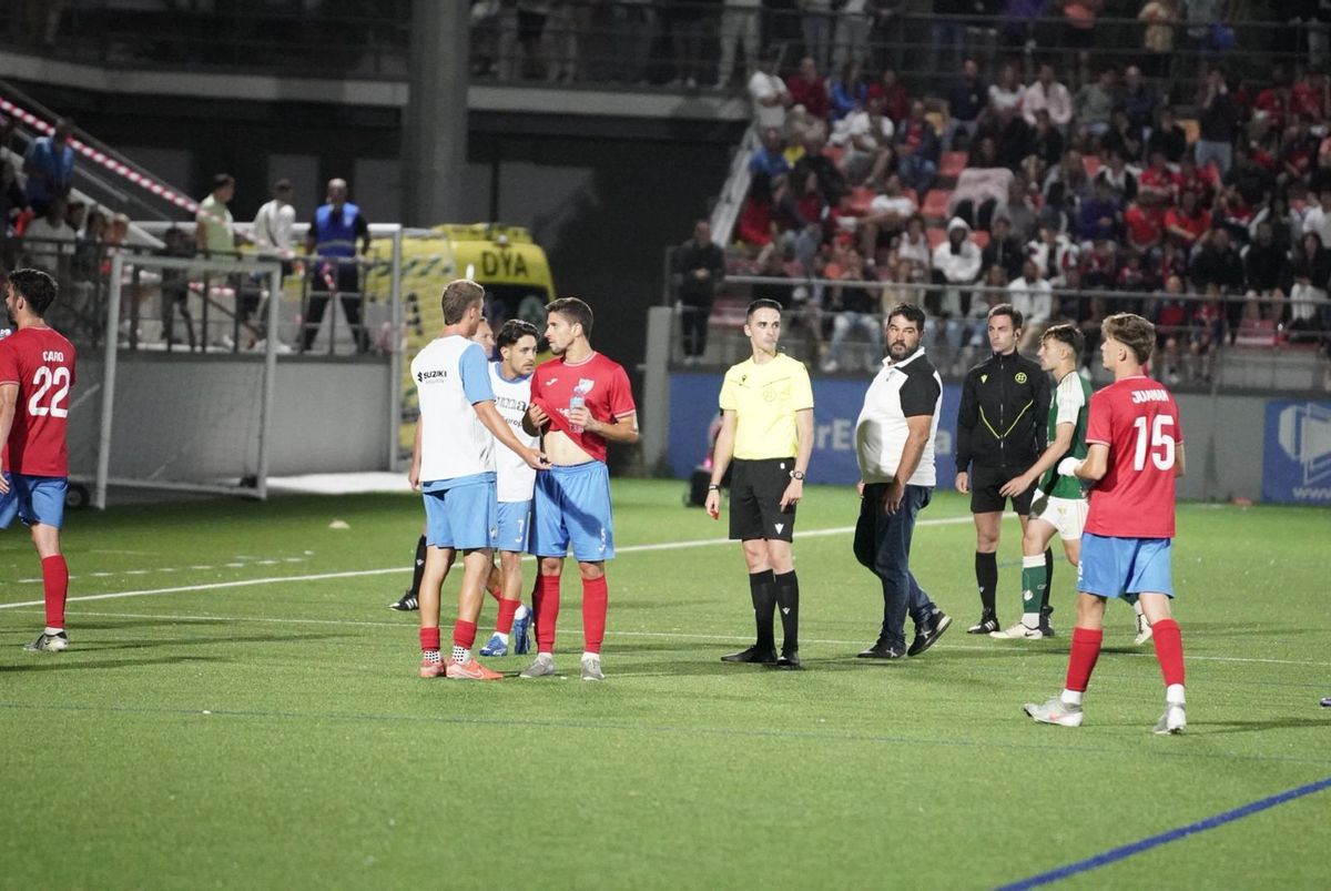 Jugadores y árbitro en el primer parón.