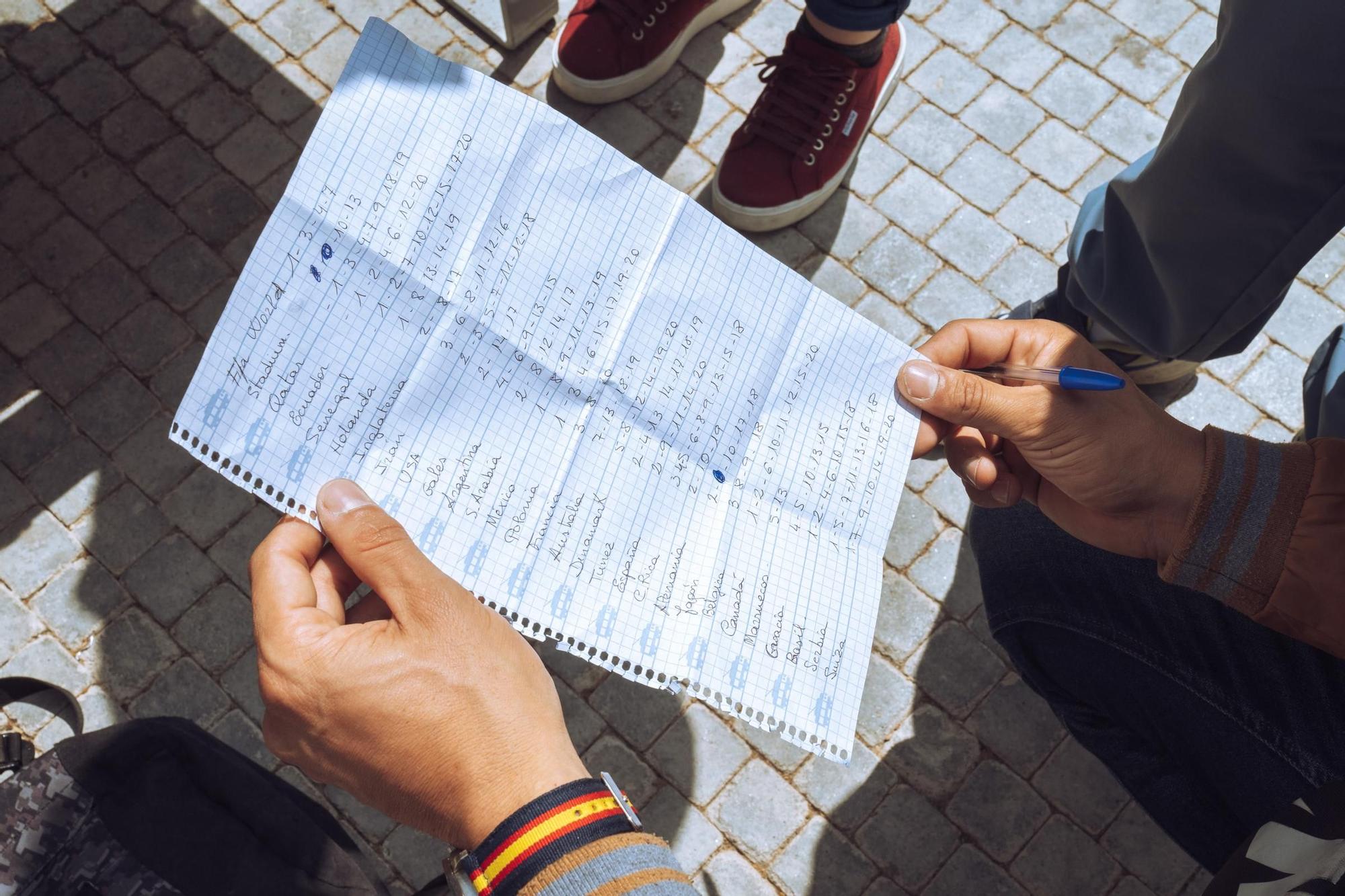 Los familiares ayudan a los niños y niñas con sus listas.