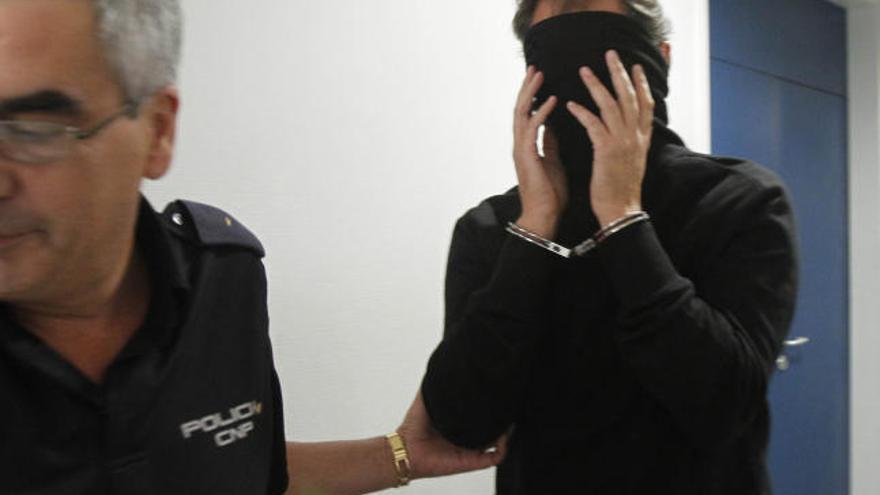 Uno de los detenidos oculta el rostro en los juzgados de Vigo.  // Lores