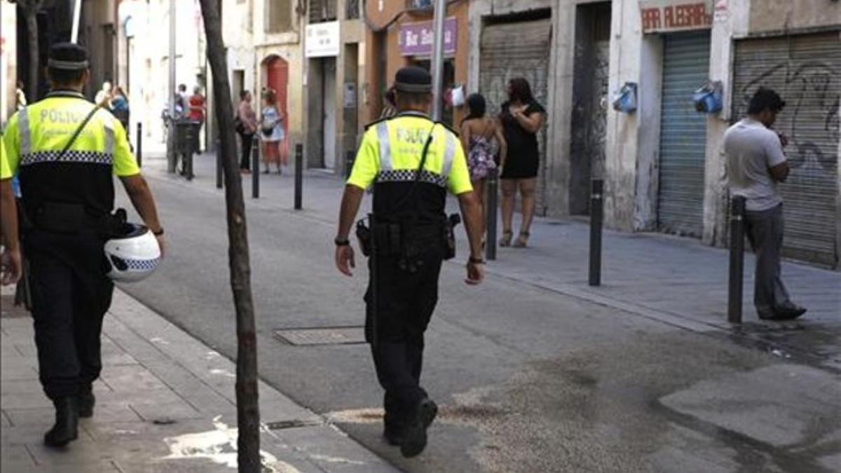 Agentes de la Guardia Urbana patrullan en la calle de Robador de Barcelona.