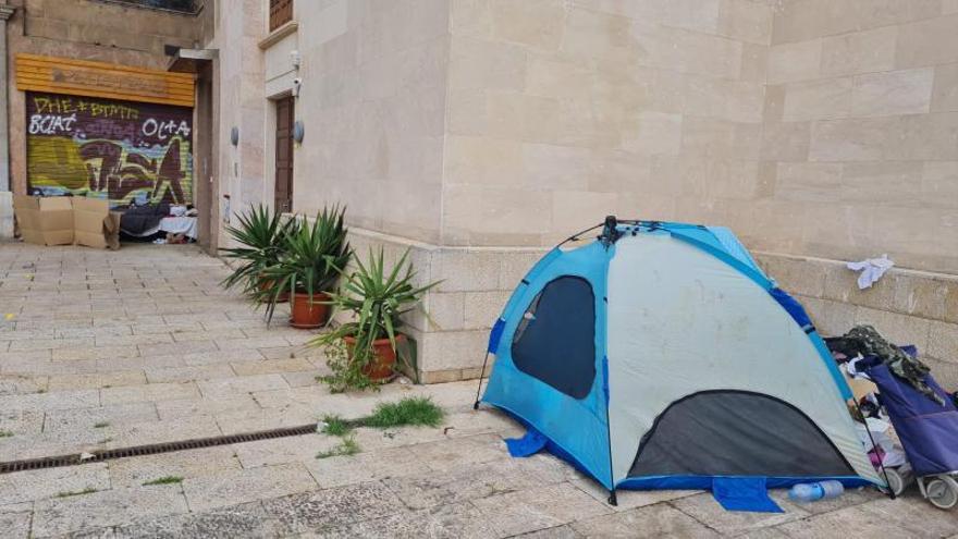 Personas sin techo acampan junto a las escaleras de la plaza Major en Palma